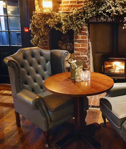 A fireplace and a seating area inside The Red Lion.