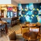 Interior dining area of a pub with a bar, a fireplace, and a few dartboards.