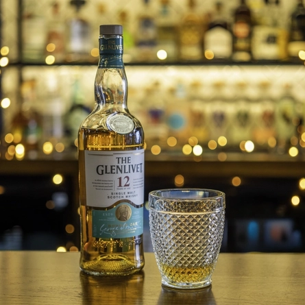 A bottle and poured glass of Glenlivet Whiskey.