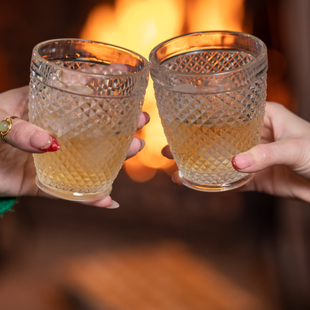 Two hands holding Glenfidditch cocktails and cheersing.