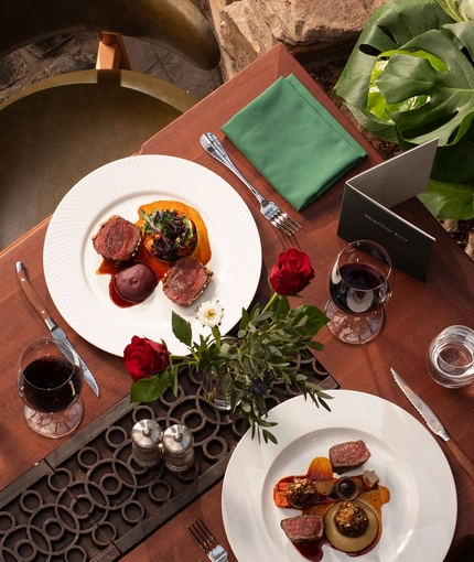 A view of one of the tables within the interior restaurant and seating area viewed from above with hanging plants at The Ubiquitous Chip.