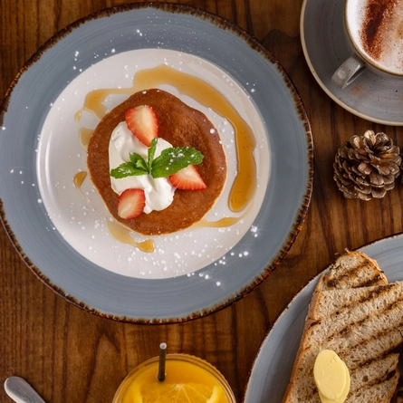 a few plates of food sitting on a wooden table of a pub