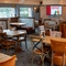 The interior restaurant seating area at the Cuckoo Oak in Madeley, with upholstered chairs, booth seating, and TVs on the walls.