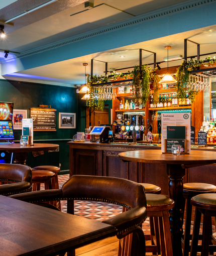 The interior restaurant seating area and wood panelled bar inside The Junction, with gaming machines.