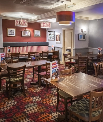 Interior dining area of a pub with a TV.