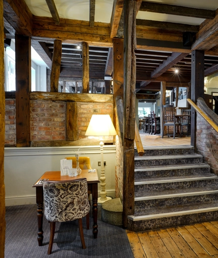 A table next to some stairs in The Rising Sun Inn.