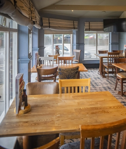 Interior dining area of a pub with a TV.