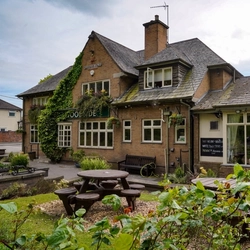 Exterior facade and beer garden of a pub with a seating area.