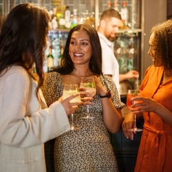 An interior shot of people enjoying summer drinks at the bar at Urban Core & Heritage venues.