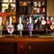 The interior bar focusing on a pump with several pump clips including Peroni, Estrella, Level Head, Hazy Day, Green King IPA, Abbot, Three Jolly Butchers Pale Ale, Tribute, Guinness, Aspall Cyder, Camden Hells and Birra Moretti all served at the Three Jolly Butchers.