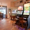 Interior dining area of a pub with two gambling machines and a pool table.