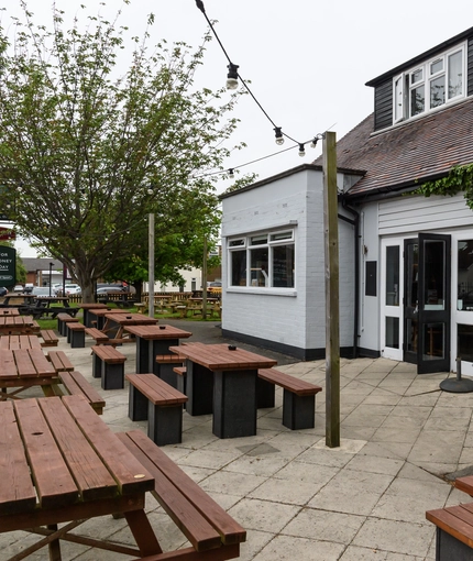 Exterior beer garden of a pub with a seating area.