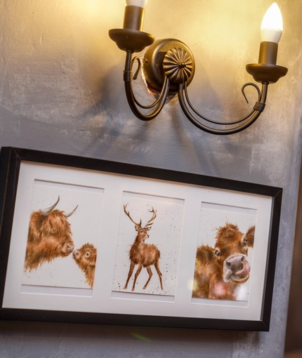 Picture of cows and a deer on a wall