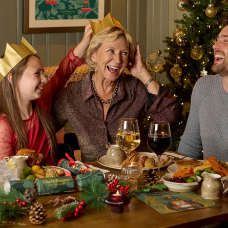 A banner showing a family sat at a table enjoying drinks and Christmas Day dishes at a Chef & Brewer venue.