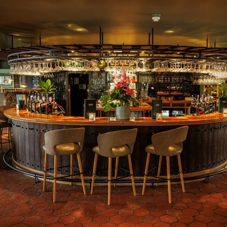The bar area, surrounded by bar stools in The Boat.