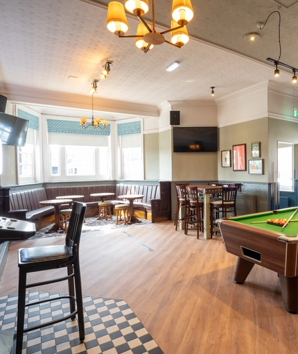The interior pub games area with pool table, seating and TV at the Black Horse.