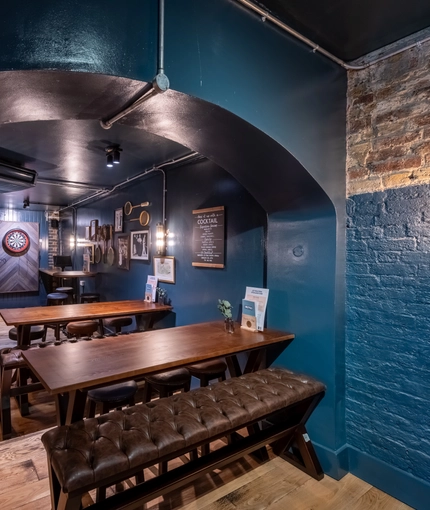 A bench near a dart board in the Prince Of Wales.