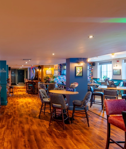The interior restaurant seating area at the Counting House, with gaming machines, TVs on the walls, a pool table, and dartboards.