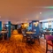 The interior restaurant seating area at the Counting House, with gaming machines, TVs on the walls, a pool table, and dartboards.