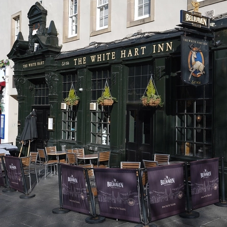The exterior facade with seating area at The White Hart.