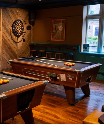 The interior pub games area with 2 pool tables and TV at the Ship and Royal.