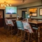 An interior restaurant seating area at The Ship in Bedford; with framed artwork, wood panelling, and a TV on the wall.
