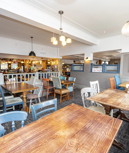 Interior dining area of a pub with a gambling machine.