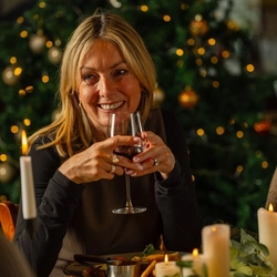A close up image of a customer sat at a table with a main dish and glass of red wine within the interior restaurant seating area at a Venture Hotel venue.