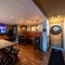 Interior dining area of a pub with a TV and a dartboard.