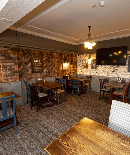 Interior dining area of a pub with a TV.