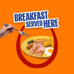 A promotional banner saying "Breakfast Served Here", with a full English breakfast of bacon, sausages, baked beans, hash browns and a fried egg on an orange background.