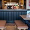 The bar and interior restaurant seating area of The Amington in Tamworth, with upholstered bench seating, and a gaming machine.