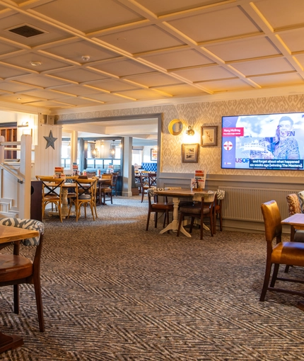 The interior restaurant and seating area with TV at the Poachers 