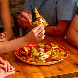 An image of people enjoying a nacho sharer dish within the interior of a Hungry Horse venue.