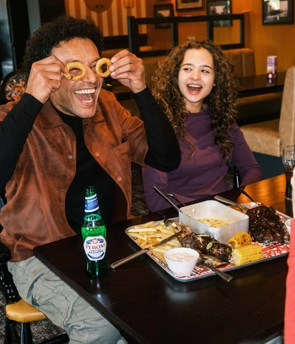 A family enjoying a meal and drinks in the interior restaurant from the new Spring/Summer menu at Flaming Grill.
