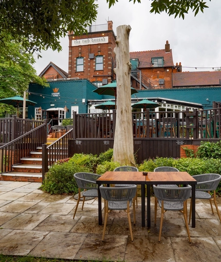 The exterior beer garden seating area with the venue in the background at The Two Greens.