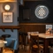 An interior restaurant seating area at the Cuckoo Oak, with upholstered chairs, and a dartboard on the wall.