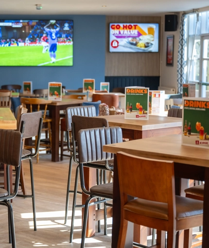 The interior restaurant and seating area with TV at the Woodlands Edge.