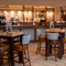The bar and interior restaurant seating area at The Wall's End, with upholstered bar stool seating, and patterned tile flooring in front of the bar.