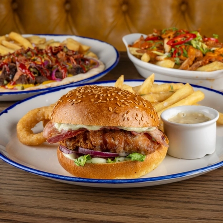 A selection of June Burger of the Month dishes on an indoor table.