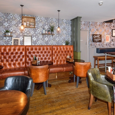 Interior dining area of a pub with a gambling machine.