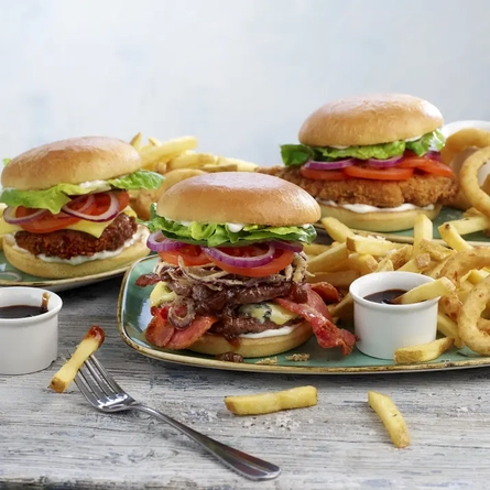 Three burgers, chips and onion rings