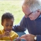 A grandad and a grandchild painting together