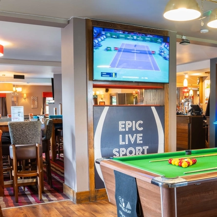 The interior restaurant seating and gaming area, with a TV on the wall and a pool table.