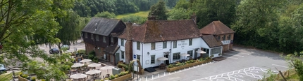 The exterior facade with beer garden seating area, signage and the car park at the Vauxhall Inn.