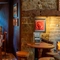 An interior restaurant seating area at The Red Lion; with wooden beams on the ceiling, stone walls, and a fireplace.