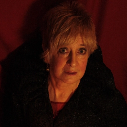 An image of Cath Edwards holding a candle advertising a Halloween Storytelling What's On event at Crafted venues.