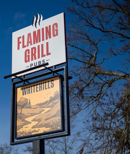 A close up view of the exterior sign post of Whitehills in Northampton.