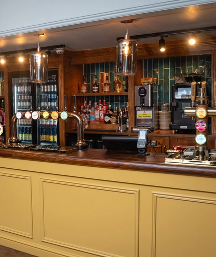 The bar inside the Tredegar Arms in Bassaleg, with lights hanging above the counter.