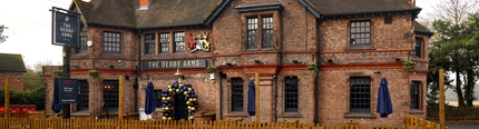 The exterior facade and seating area at The Derby Arms.